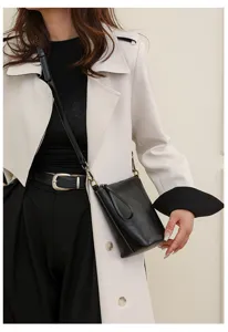 Detailed shot of a sleek black bucket bag worn by a model, featuring minimalist everyday style.