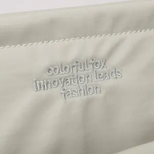 Nylon laptop bag close-up detail, showing fine embroidery texture and waterproof fabric.