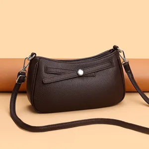 Brown leather shoulder bag detail, stylish crescent shape with metallic clasp and adjustable strap.