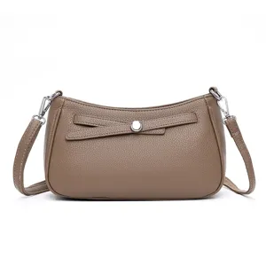 Stylish taupe leather crossbody bag with silver hardware and chic front strap detail for women.