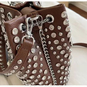 Stylish brown rhinestone studded bucket bag with silver chain detail, perfect for daily wear.