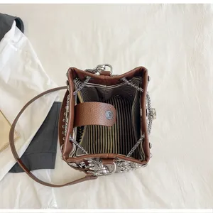 Detailed interior view of the leather bucket bag showing striped lining and chain strap details.