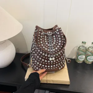 Brown rhinestone studded bucket bag with chain drawstring and pearl decor for women.