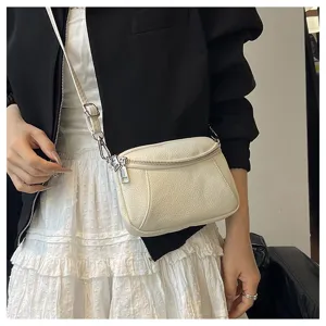 Detail close-up view of the white leather crossbody mini bag with double zippers and strap.