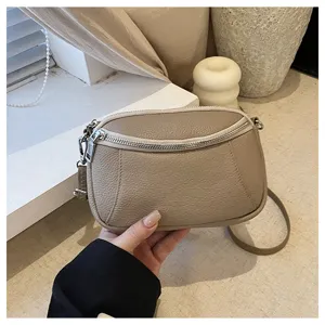 Detail view of genuine leather mini crossbody bag, soft pebble texture, double zipper closure.