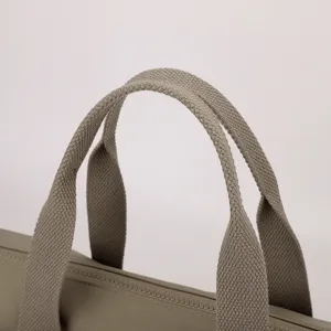Vue détaillée de la poignée du sac cabas en nylon et de la fermeture éclair.