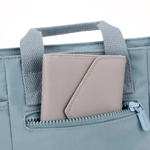 Gros plan sur la poche zippée avant et la poignée supérieure d'un sac en nylon décontracté.