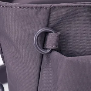 Gros plan détaillé du sac à épaule en nylon violet avec boucle anneau et couture.