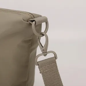 Gros plan détaillé du sac bandoulière en nylon montrant la quincaillerie et la boucle.