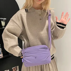 Lightweight purple multi-layer canvas crossbody bag detail shot, casual daily fashion style.