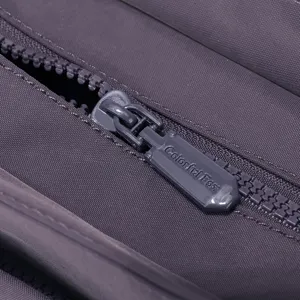 Gros plan sur le détail de la fermeture éclair du sac en nylon violet, texture fine.