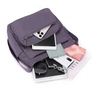 Detailed view of purple nylon crossbody bag showing multi-pocket storage capacity and inner design.