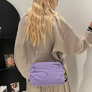 Lightweight purple multi-layer crossbody canvas bag worn detail, casual daily fashion style.