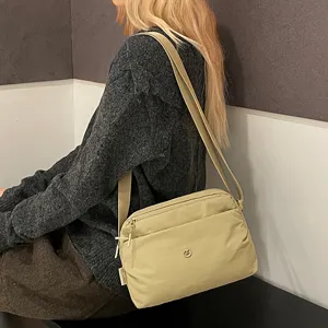 Casual multi-layer canvas crossbody bag for women, versatile lightweight shoulder messenger bag.