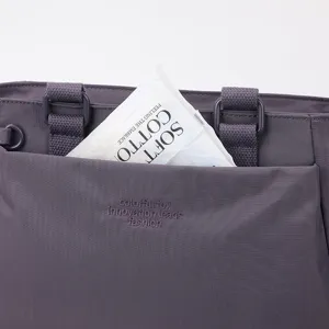 Détail de sac cabas en nylon avec poche avant, tissu durable et coutures soignées.