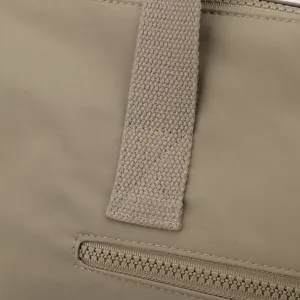 Detail de sac de voyage en nylon montrant un tissu durable, une poignée solide et une fermeture.