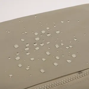 Gros plan sur le tissu en nylon imperméable avec des gouttes d'eau, montrant une forte résistance.