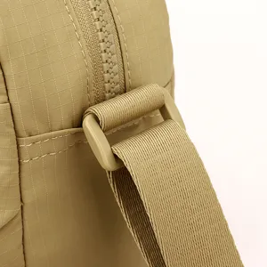 Khaki crossbody bag detail closeup, showing durable grid fabric, zipper, and strap.