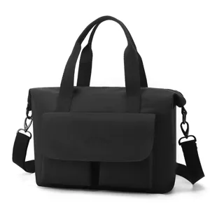 Vue détaillée du sac cabas en nylon noir, montrant la poche à rabat avant et les coutures solides.