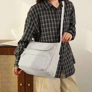 Casual canvas shoulder bag, detailed view of multi-pocket design and cross body strap.