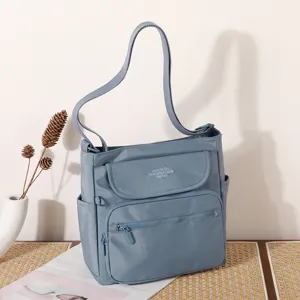 Detailed view of the blue nylon shoulder crossbody bag with multiple pockets and adjustable strap.