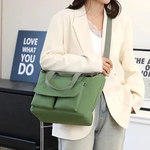 Vue détaillée du sac cabas bandoulière en nylon vert, montrant poches avant et bandoulière.