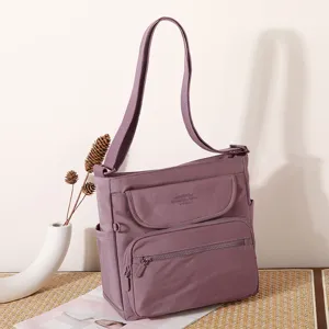 Detailed view of the purple canvas shoulder bag featuring multiple pockets and flap design.