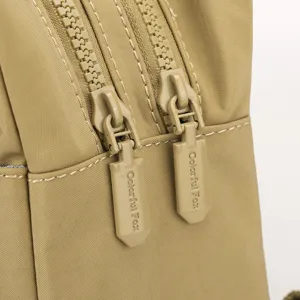 Primo piano dettagliato delle doppie cerniere dello zaino casual in nylon color cachi.