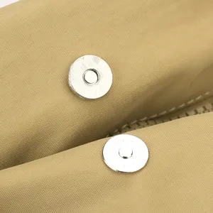 Vista dettagliata del bottone magnetico a pressione e della texture in tessuto dello zaino.
