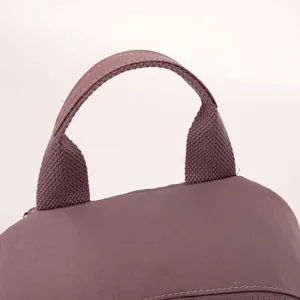 Primo piano del manico dello zaino in tessuto resistente con cuciture pulite e texture.