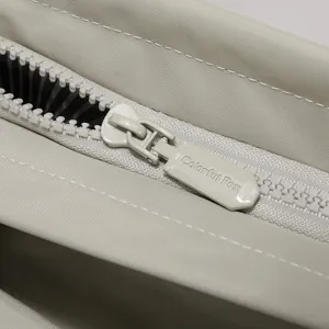 Detailed close-up of waterproof nylon laptop bag zipper with custom pull tab and fine stitching.