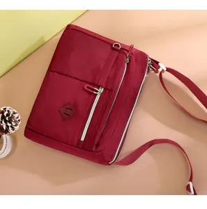 Red nylon crossbody bag for women, trendy casual shoulder bag with multiple zippered pockets.
