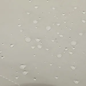 Close-up detail of waterproof nylon fabric with water droplets showing water-resistant property.
