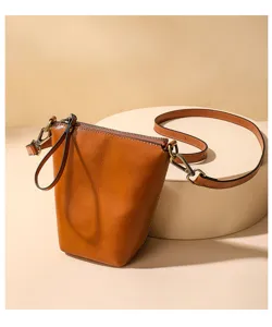 Brown leather crossbody bag detail featuring vintage metal hardware, zipper and adjustable strap.