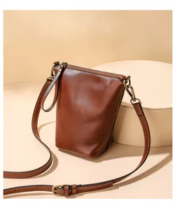 Detailed view of the brown leather crossbody shoulder bag showing smooth texture and metal hardware.