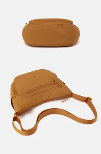 Close up detail view of brown nylon crossbody bag featuring multi zipper pockets and sturdy strap.