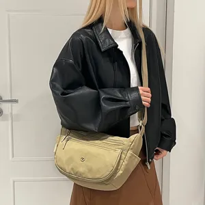 Casual nylon crossbody bag worn by model, highlighting multi-pocket design and strap detail.