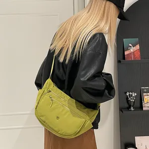 Casual nylon crossbody bag detail showcasing multi-compartment design and smooth zipper.