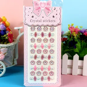 Detail view of colorful crystal rhinestone stickers sheet with pink bow card for DIY crafts