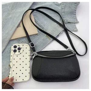 Detail view of black leather mini crossbody bag with double zippers and slim strap.