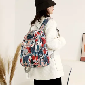 Vista dettagliata del elegante zaino in nylon con stampa astratta colorata e tasche anteriori.