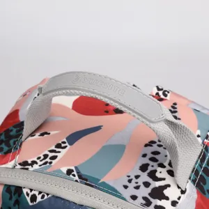 Dettaglio manico zaino, tessuto in nylon impermeabile con stampa colorata e robusta cerniera.