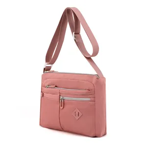 Pink nylon crossbody bag detail, multi-zipper compartments, waterproof shoulder bag style.