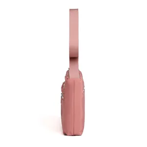 Pink nylon crossbody shoulder bag side detail view, casual waterproof trendy design.