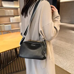 Classic black leather crossbody bag for women with wide striped strap and silver hardware.