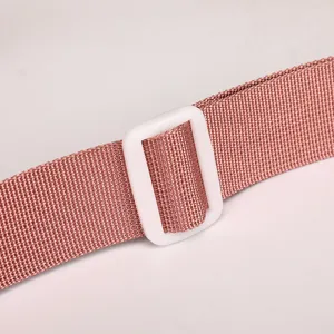 Pink nylon bag strap detail with white plastic buckle, durable and adjustable for crossbody bags.