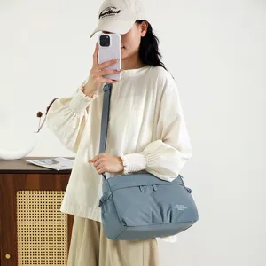 Detail view of the stylish blue-grey nylon crossbody shoulder bag featuring adjustable strap.
