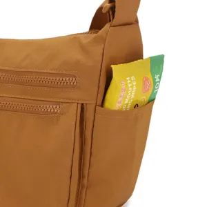 Detailed view of brown nylon crossbody bag showing side pocket functionality and multi-layer zippers.