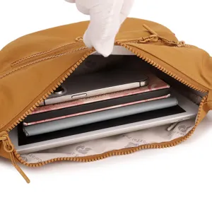 Nylon crossbody bag detail showing multi-compartment capacity, phone and tablet inside.