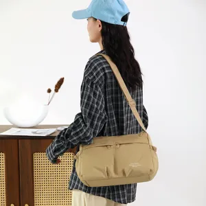 Detail view of casual nylon crossbody shoulder bag with adjustable strap and front pockets.
